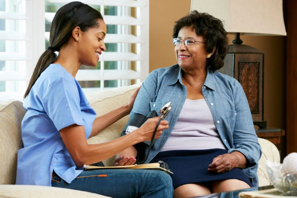 Smiling elderly woman talking with a compassionate elder care consultant at home